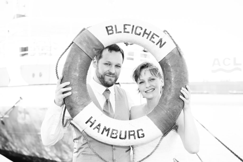 Brautpaar blickt durch einen Rettungsring Bleichen Hamburg
Die Aufnahme ist in schwarz/weiss