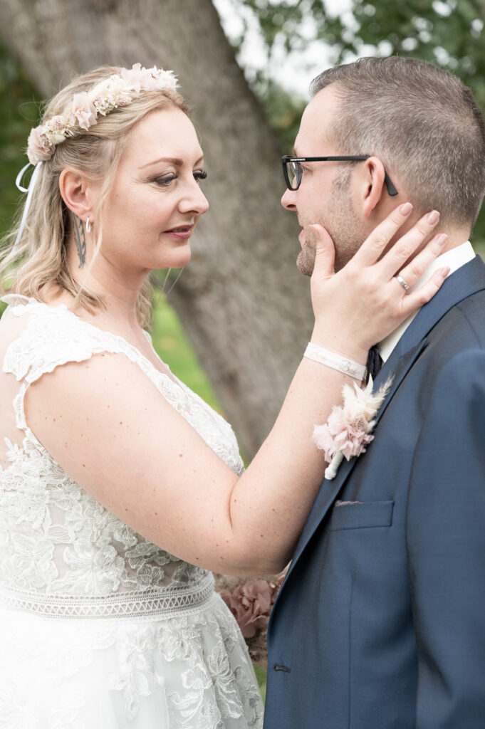 Liebevoll hält die Braut ihre Hand an das Gesicht des Bräutigam
meine Hochzeitsfotografin Brautpaar Fotoshooting Reportagebegleitung Hochzeitsfotograf